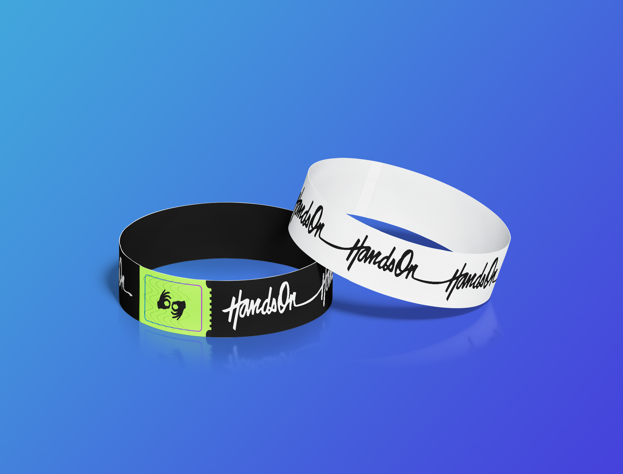 This is an image of two rubber merch bracelets featuring the Hands On logo on a blue background. One is black, with a light green accent, the other is white.
