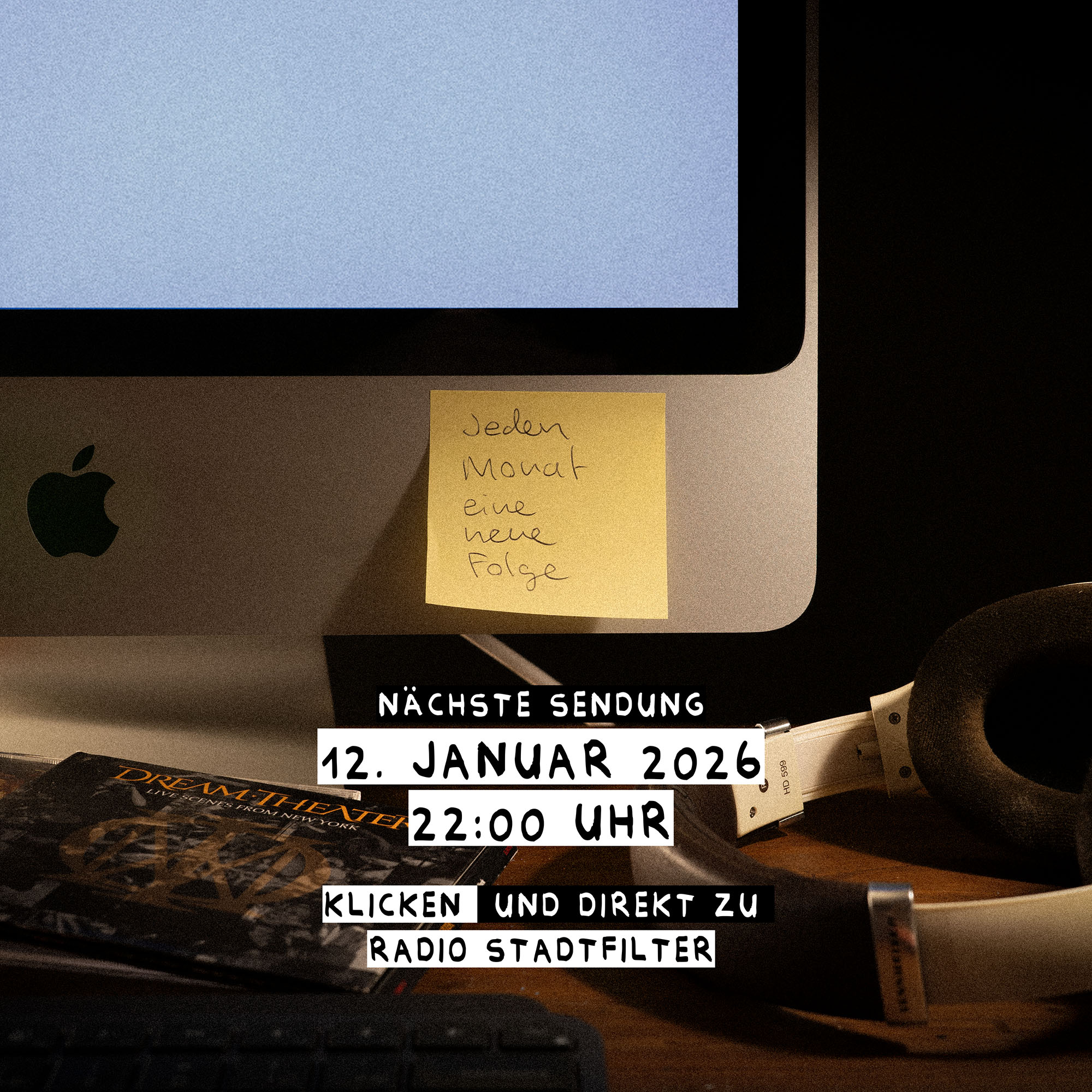 Close-up of an Apple iMac with a yellow sticky note that reads 'Jeden Monat eine neue Folge,' a Dream Theater CD, white headphones, and text announcing a radio show on January 12, 2026 at 22:00.