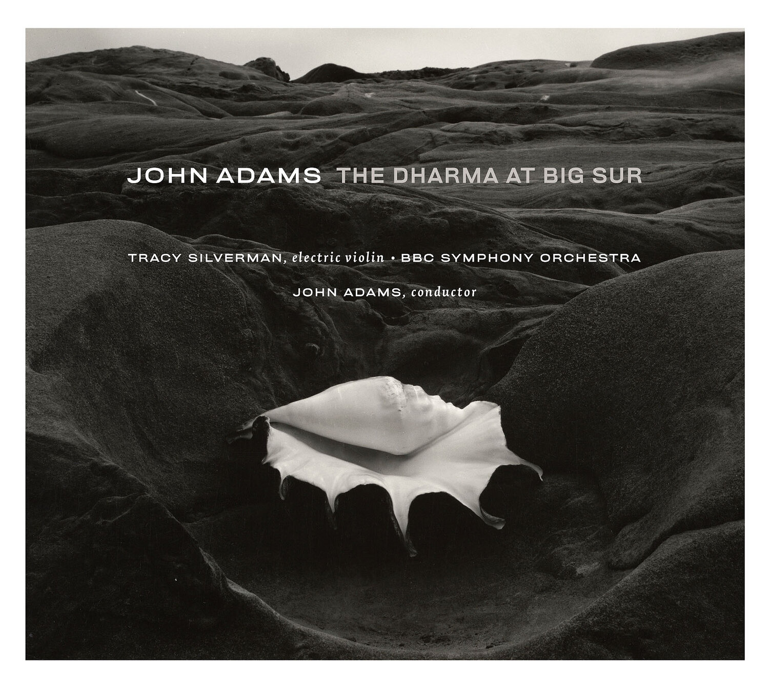 Album cover of "The Dharma At Big Sur" by John Adams. Imagery is a black and white picture of sand dunes (presumably at Big Sur) and an oversized conch shell centered in the frame.