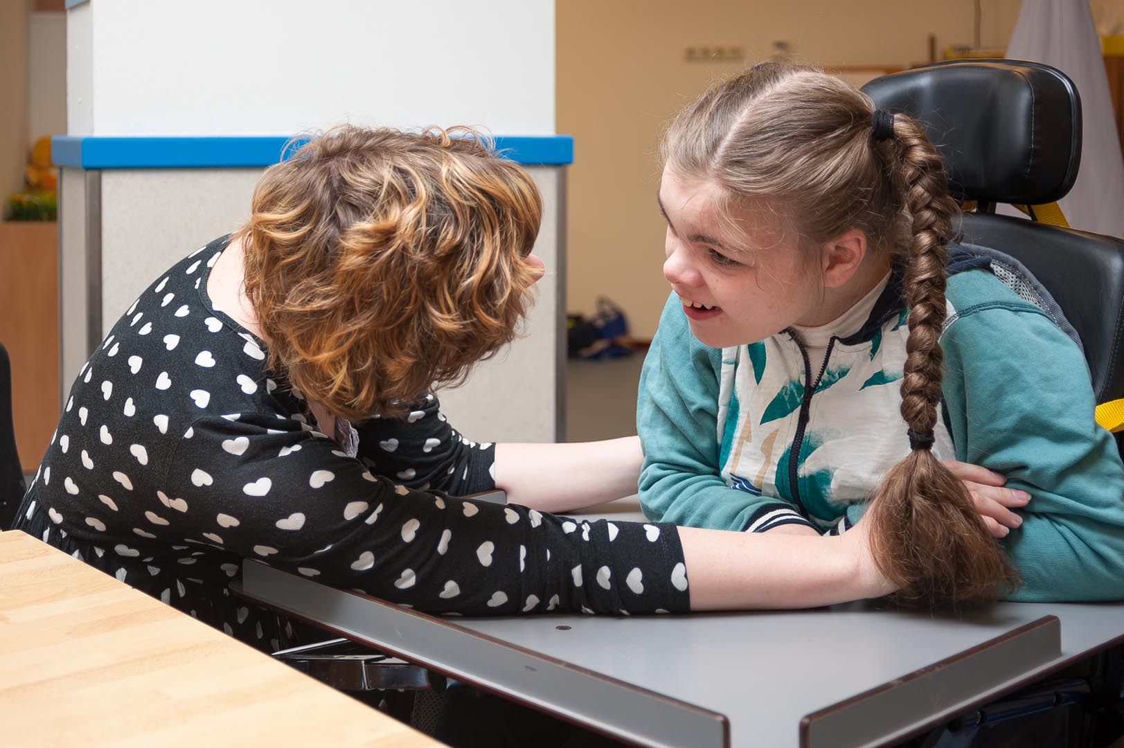 woman in black top speaking to girl with long brown hair