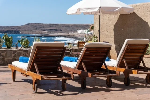 Sonnenliegen und Sonnenschirm auf der Terrasse mit Meerblick