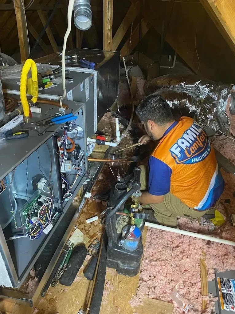 Technician cleaning ducts in a home, showcasing the benefits of duct cleaning