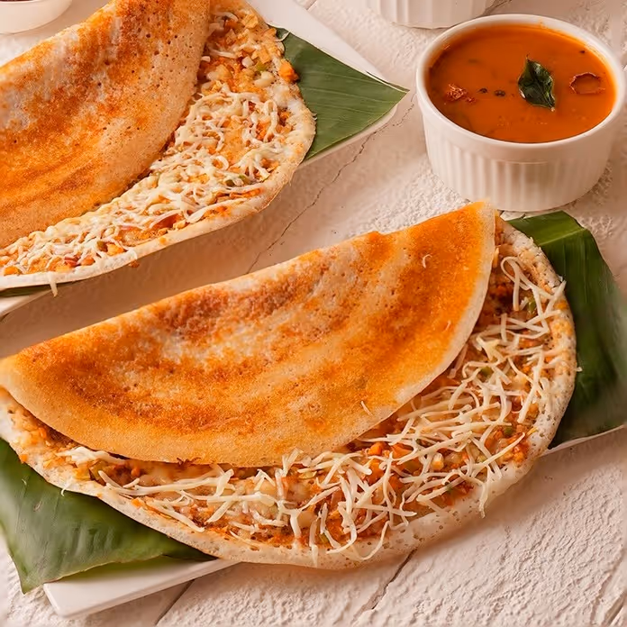 Pancake-type crispy bread made of rice and lentil batter, sprinkled with cheese.