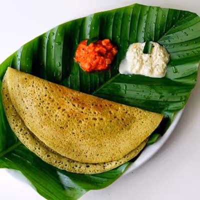 Pancake-type crispy bread made of rice and lentil batter, sprinkled with mint chutney.