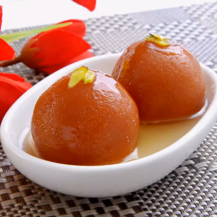 Gulab Jamoon are soft, delicious, berry-sized balls made with milk solids, flour and soaked in rose-flavored sugar syrup.