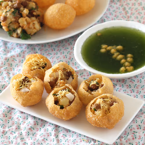 Crispy puri stuffed with potato, onion, chickpeas, and coriander chutney, drenched in sour and spicy mint-flavored water.