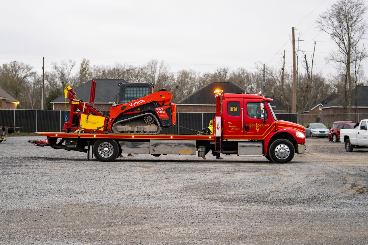 Flatbed Tow Truck Transporting Kubota Track Loader