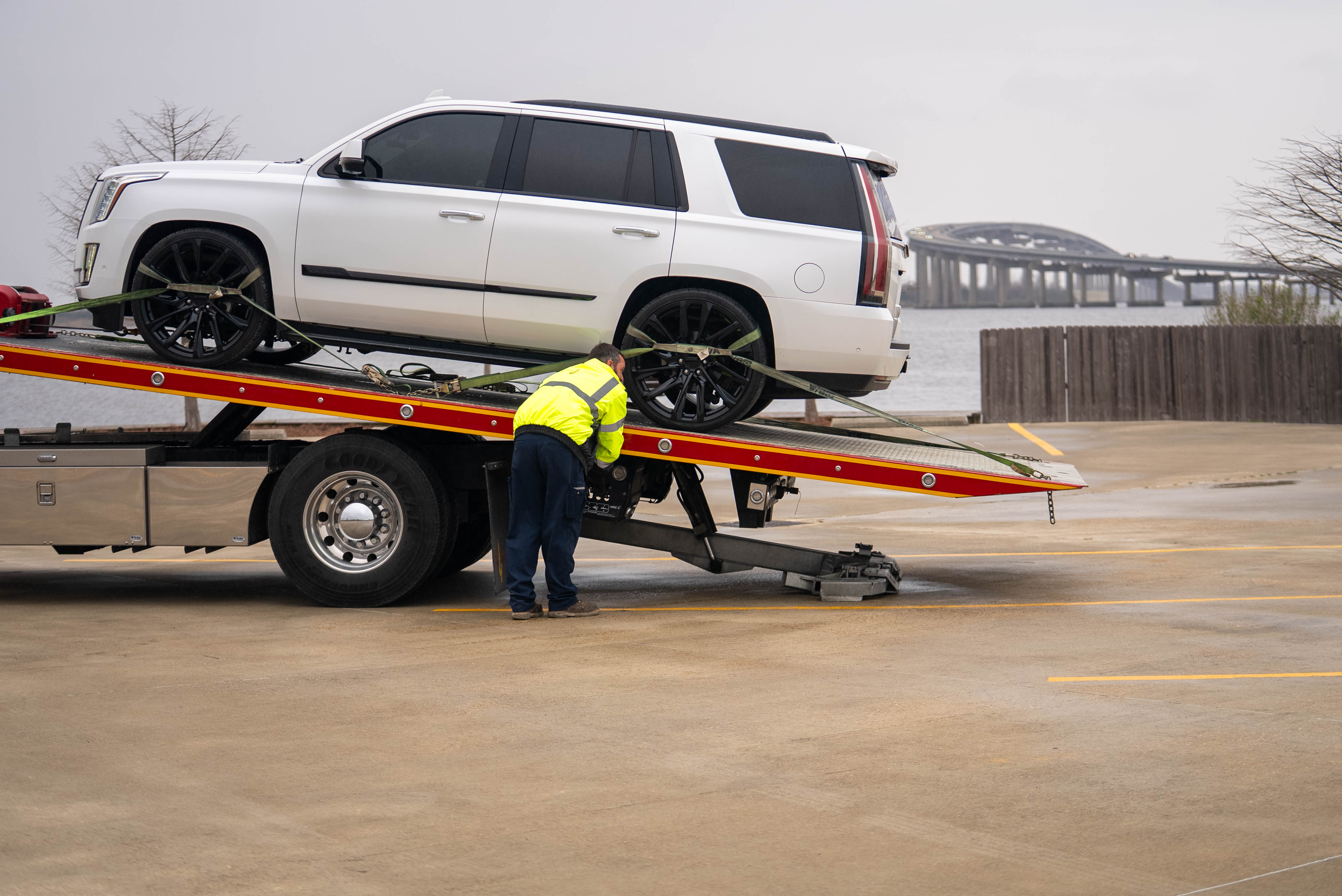 Tow Operator Securing White SUV On Flatbed