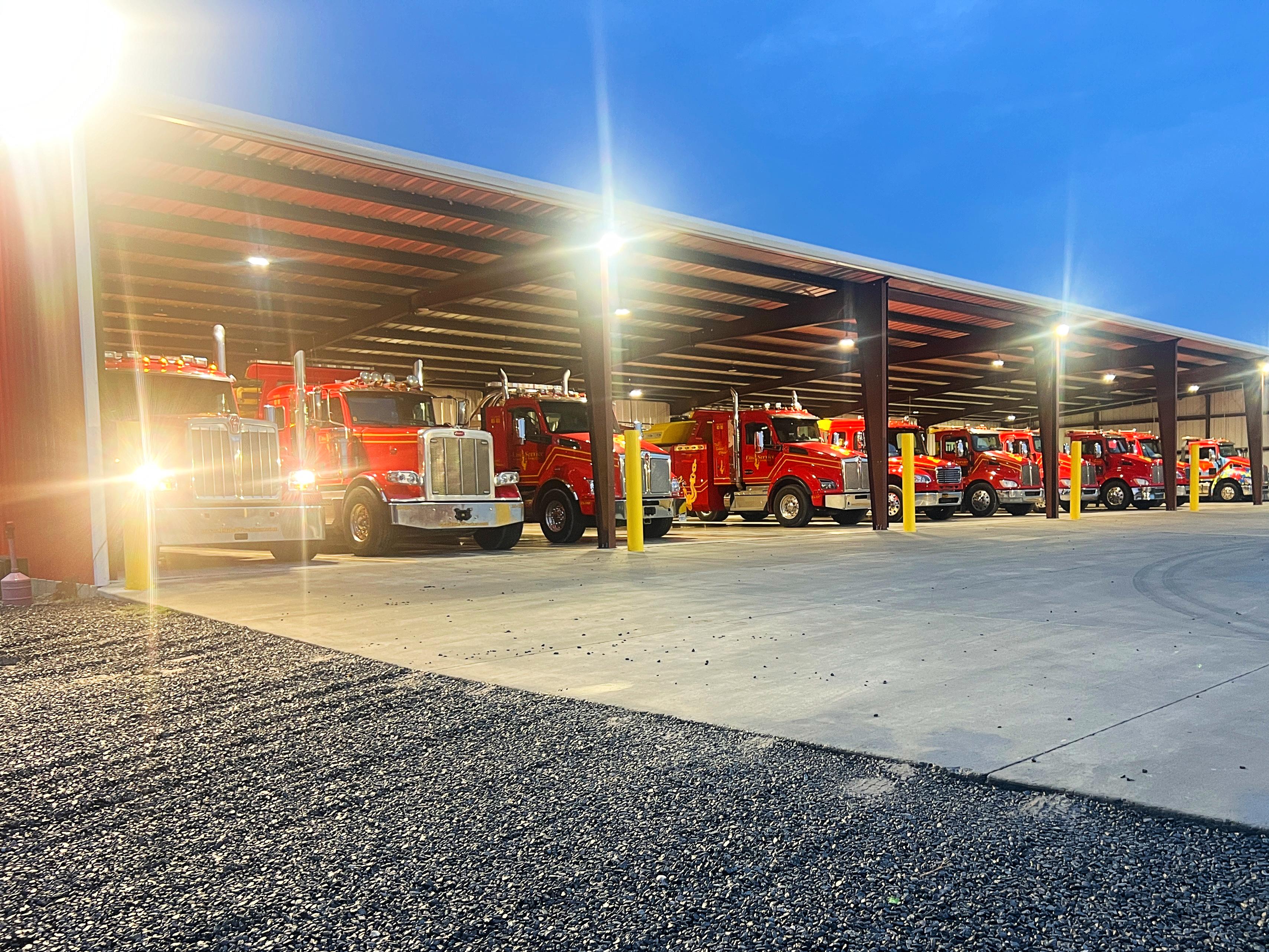 Red Tow Truck Fleet Parked Under Garage