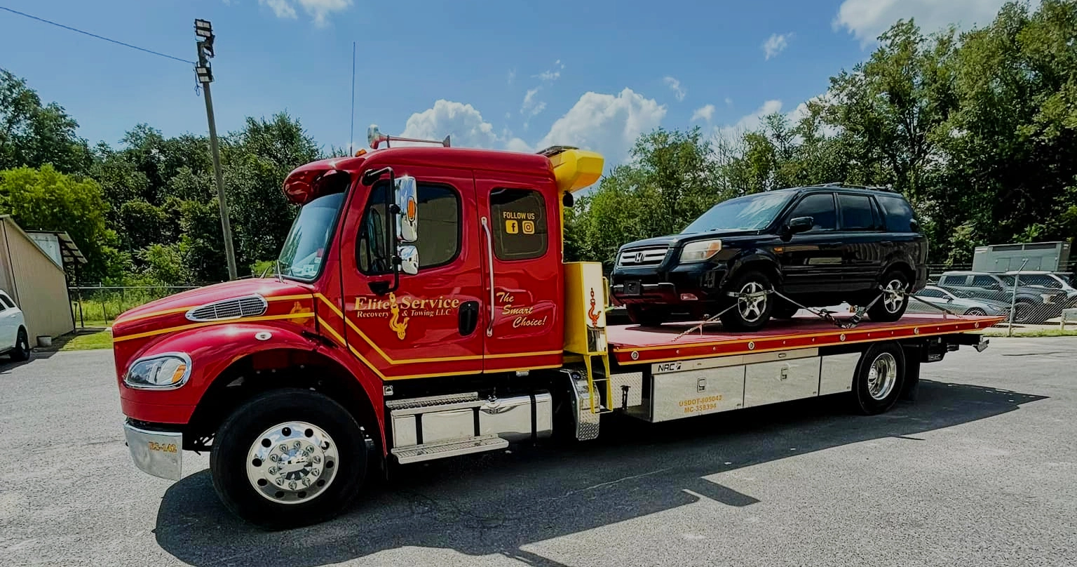 Flatbed Tow Truck Carrying Black SUV