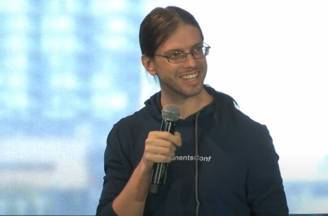 Rick Giner holding a microphone and smiling whilst delivering a presentation at Components Conf