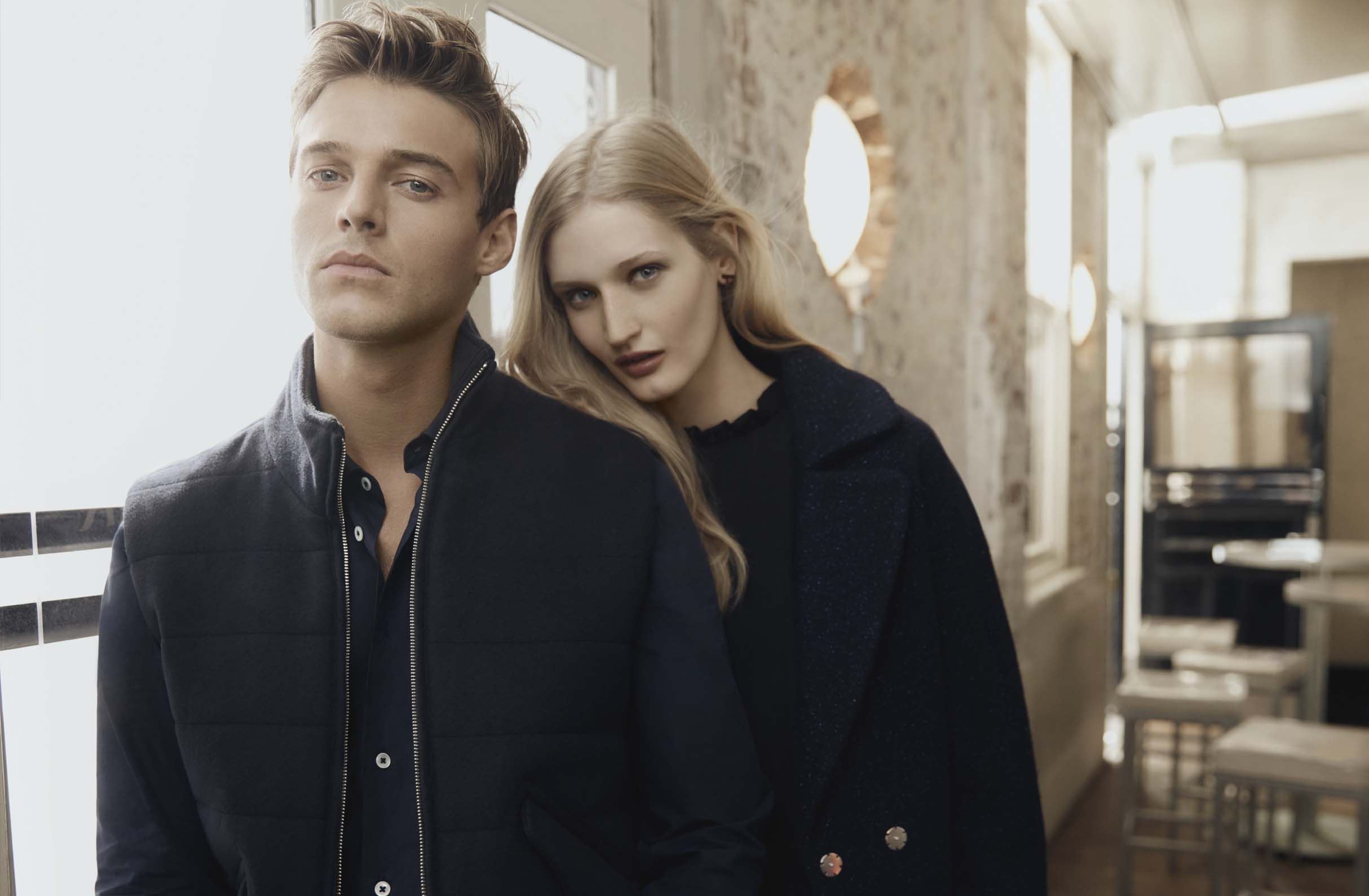 Fashion image of male and female model in a pub wearing warm clothing