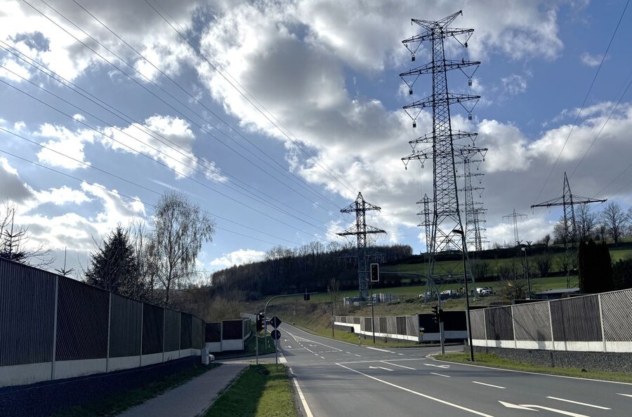 Bild vergrößern: Straße mit Hochspannungsmasten im Hintergrund