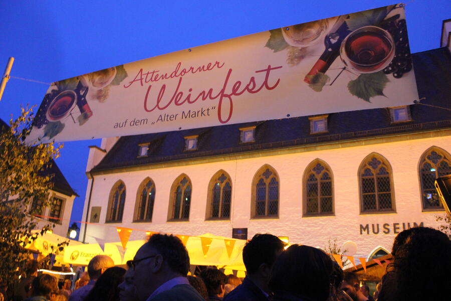 Bild vergrößern: Plakat eines Weinfestes vor historischer Fassade