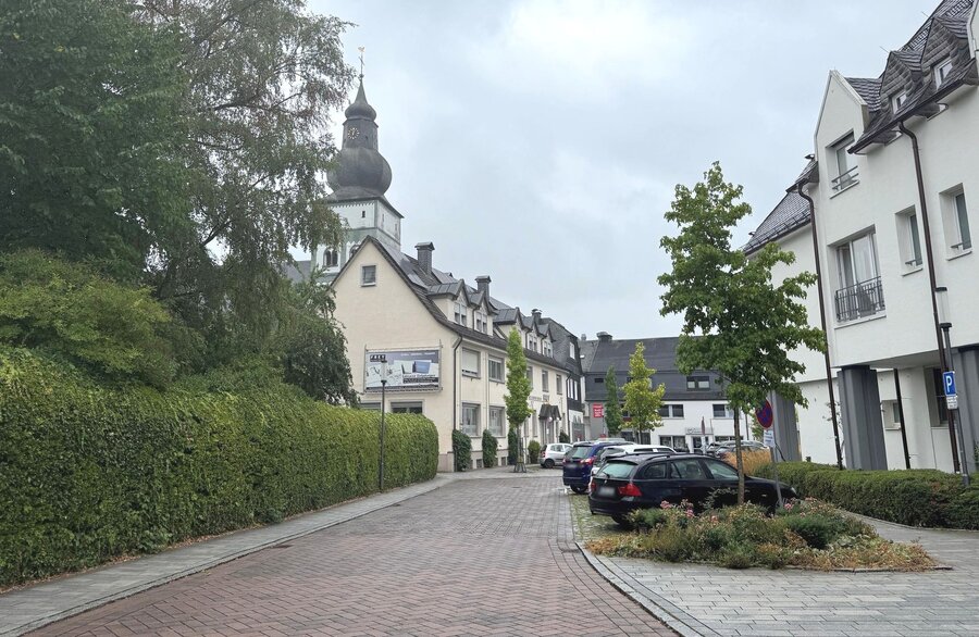 Bild vergrößern: Blick in eine ruhige Straße mit Parkstreifen