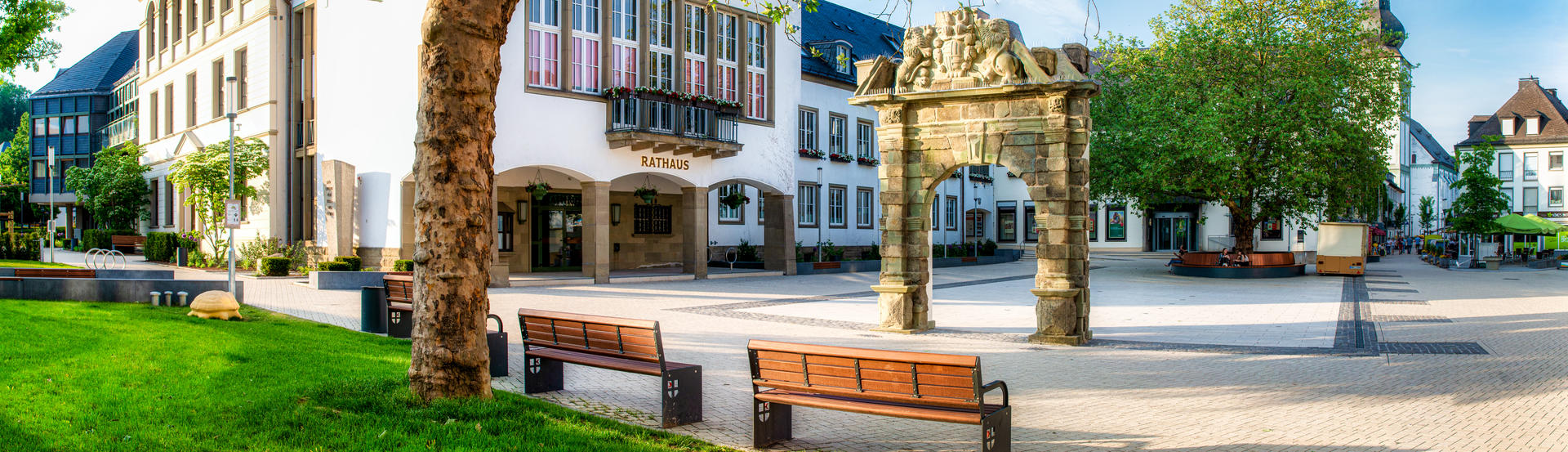Bild vergrößern: Das Attendorner Rathaus mit einem Torbogen und zwei Sitzbänken.
