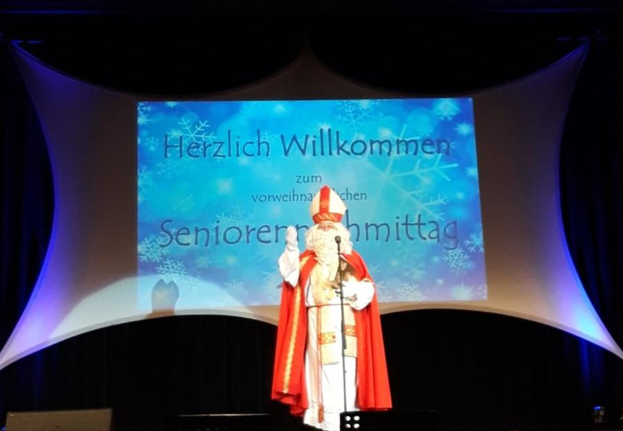 Bild vergrößern: Der Nikolaus steht beim Seniorennachmittag auf der Bühne
