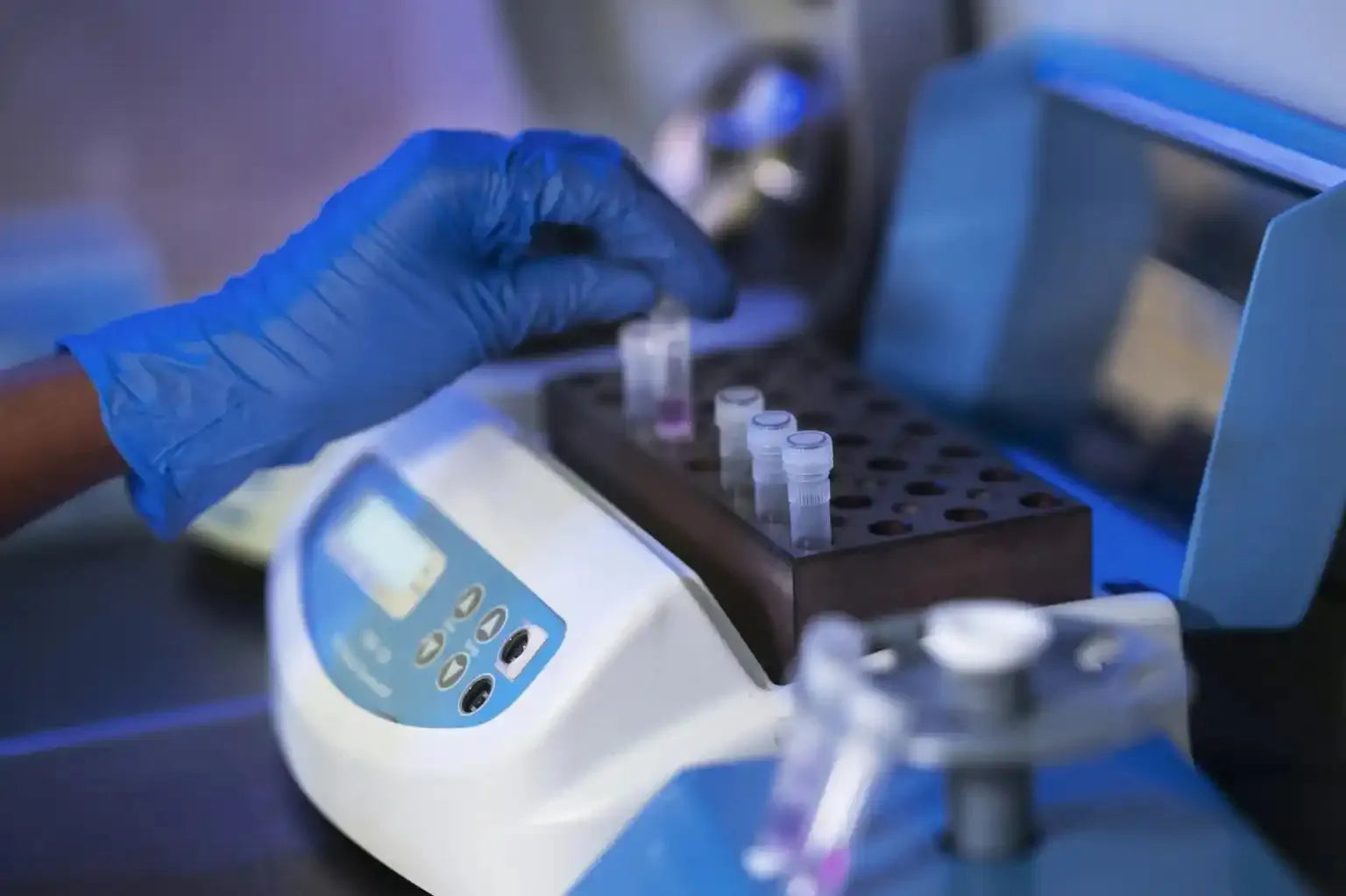 A person in blue gloves is using a machine
