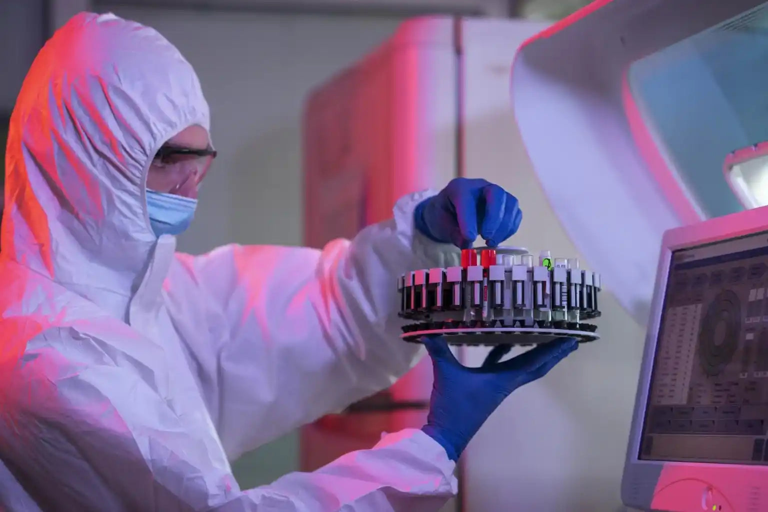 A person in a white suit holding a device