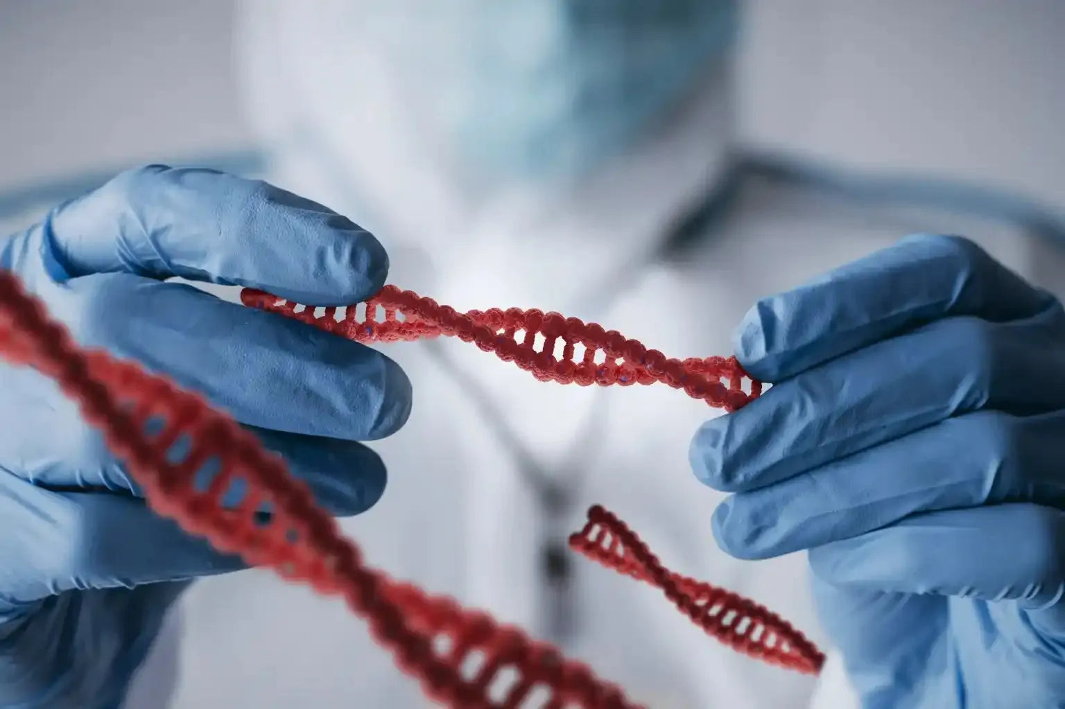 A man in blue gloves holding a strand of red string