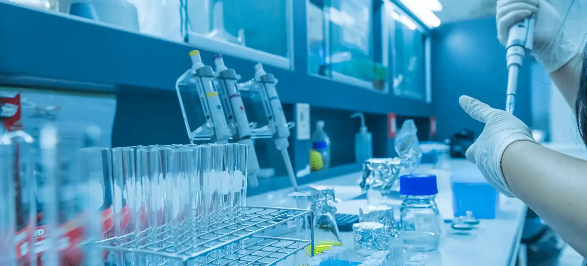 A woman in a lab coat is holding a pipe