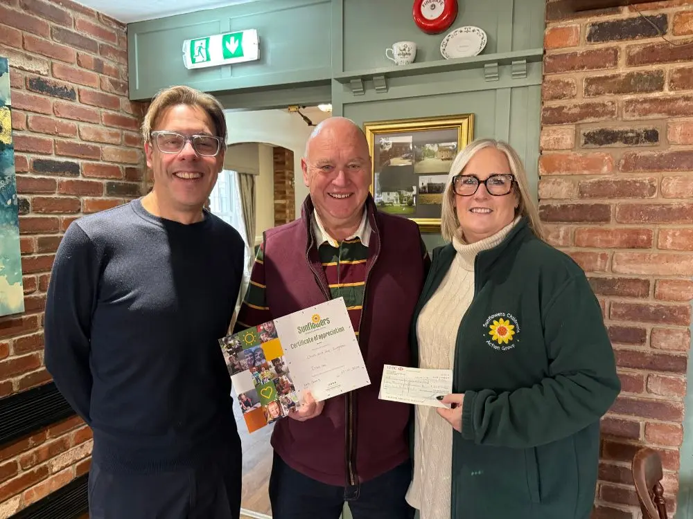 Phillip Wright and Chris Ringrose present a donation cheque and certificate to Sunflowers Trustee Kate Roberts.