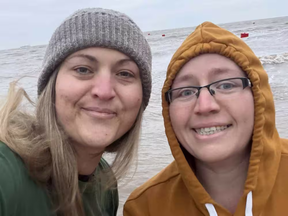 Close-up selfie of two participants on the beach during the challenge.