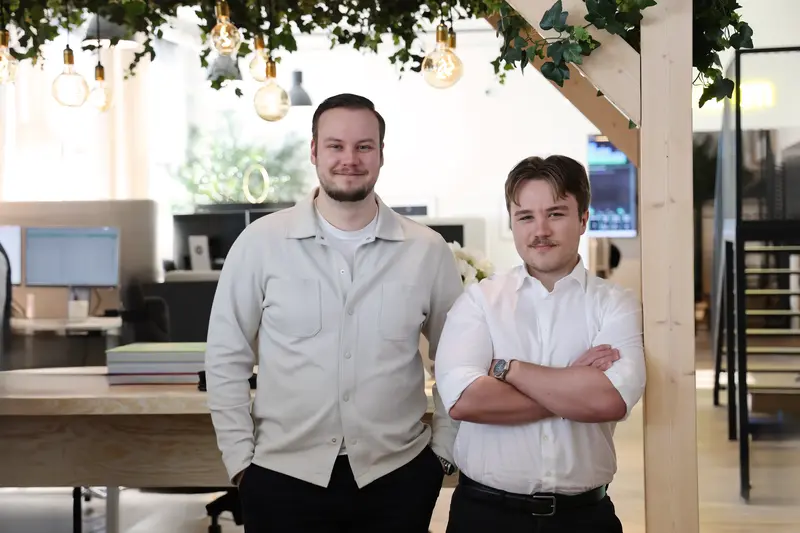 Två män som står bredvid varandra framför en pergola.