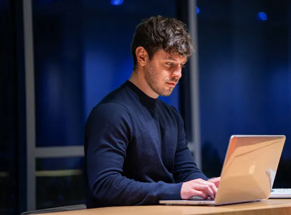man in black long sleeve shirt using macbook