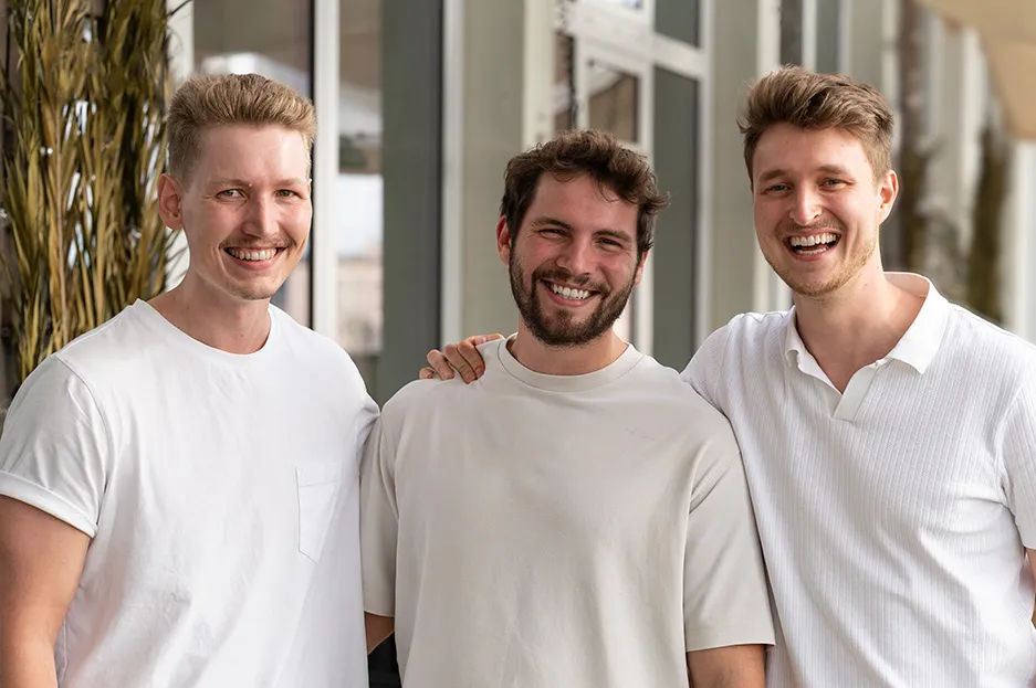 Oliver, Nils und Manuel stehen zusammen und lachen