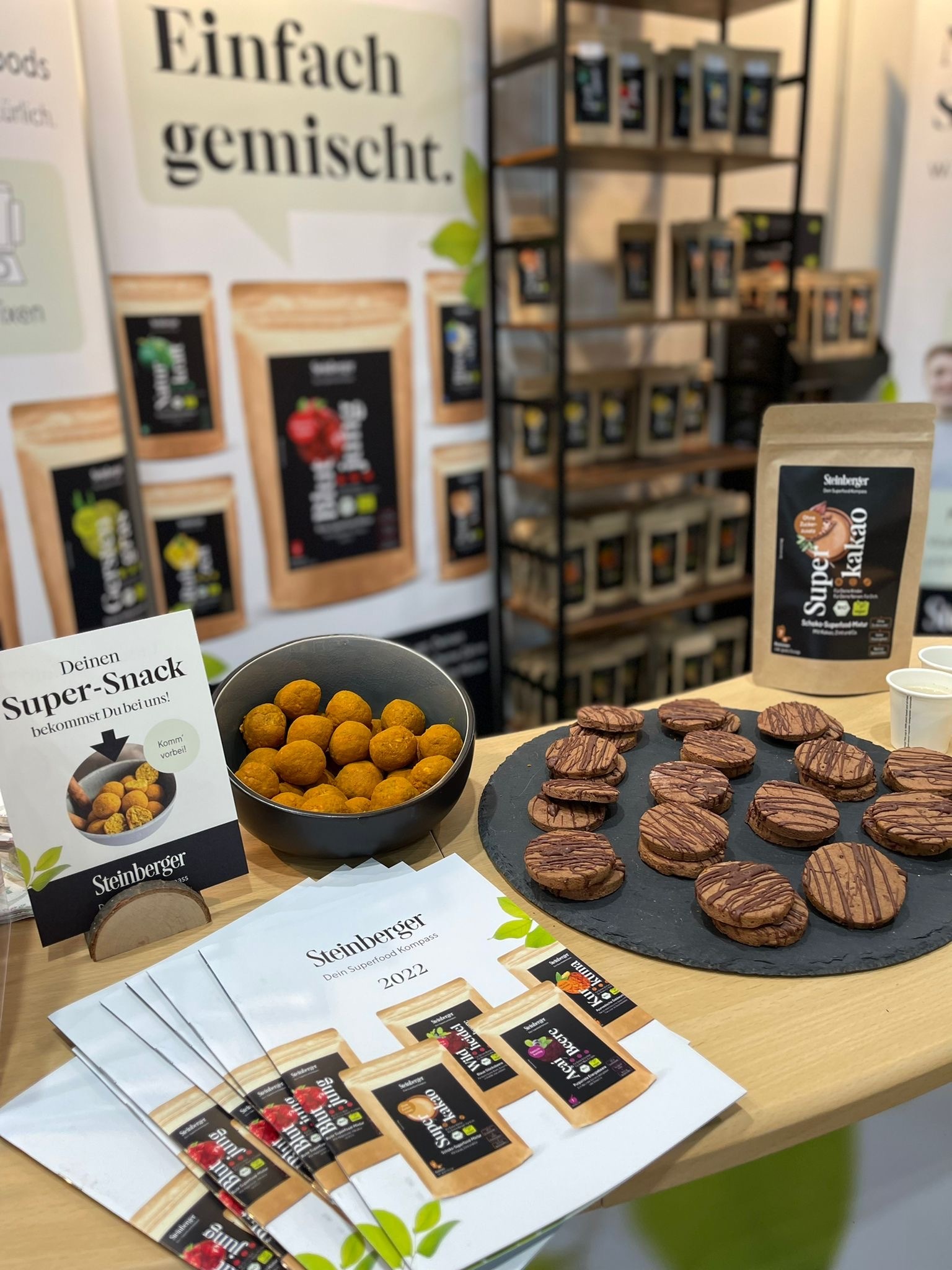Der Stand von Steinberger Superfoods bei einer Messe inkl. Produkten und daraus entstandenen Snacks