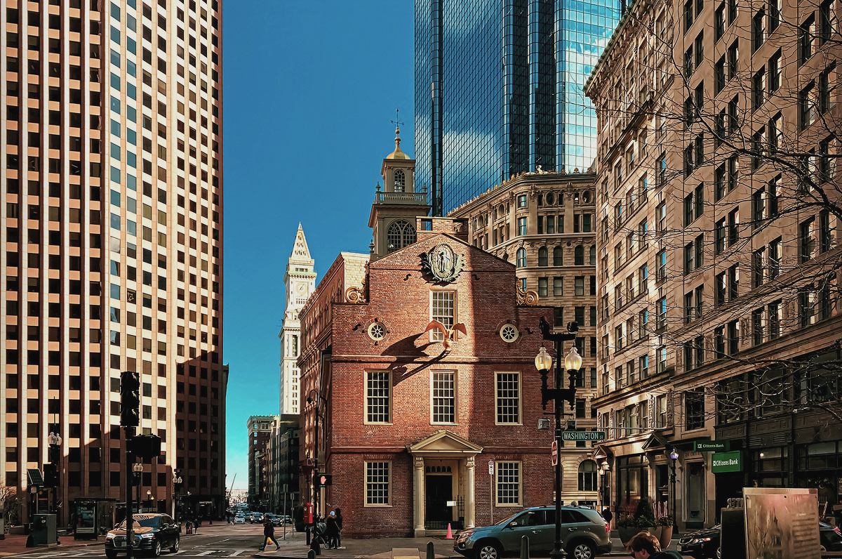 Boston's historic Old State House framed by modern skyscrapers on Washington Street, the host city for FloQast's Ad Hoc Conference 2026.