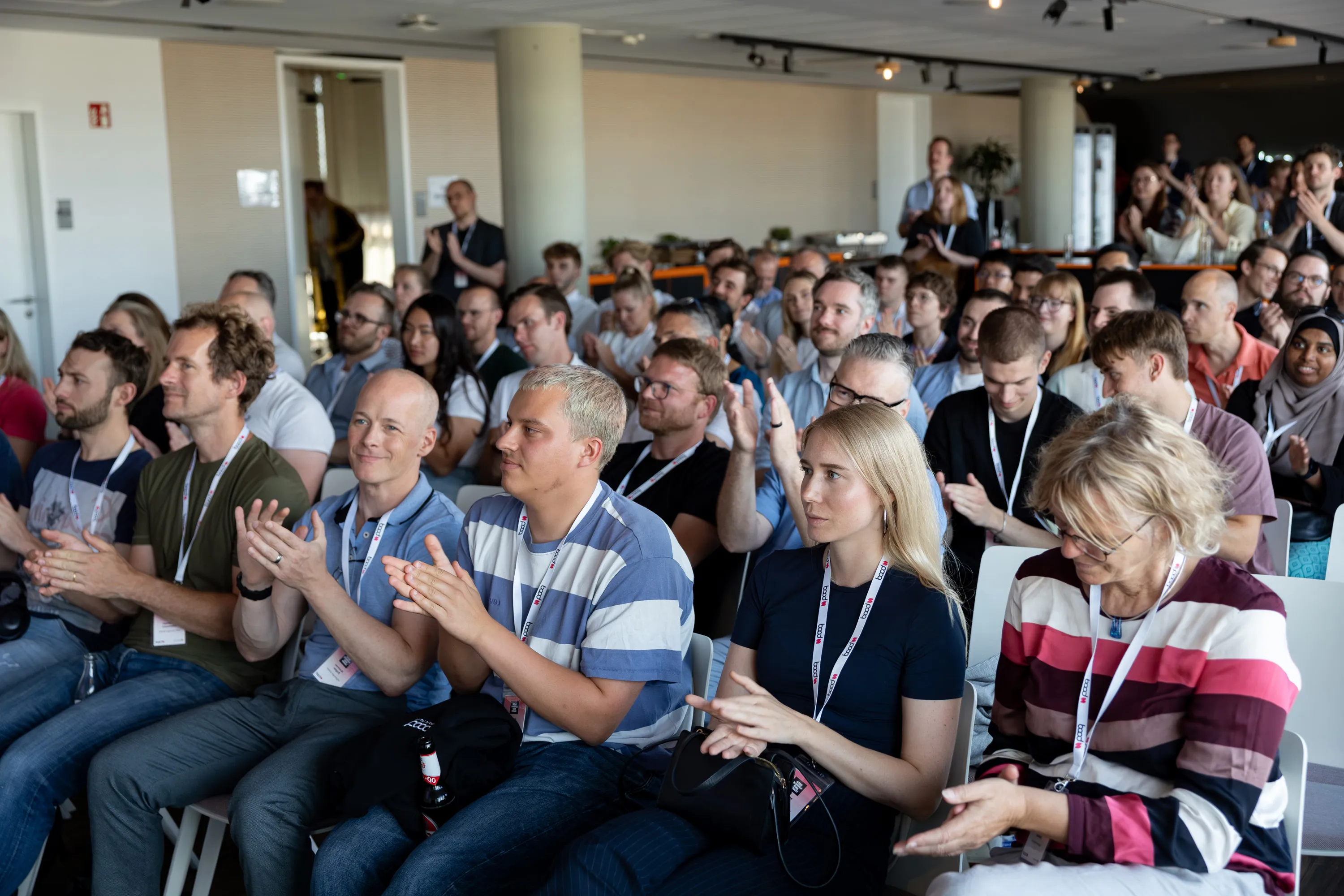 Verschiedene Menschen, die in einem modernen Konferenzraum einer Veranstaltung aufmerksam applaudieren.