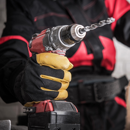 Close up of gloved hand holding a power drill