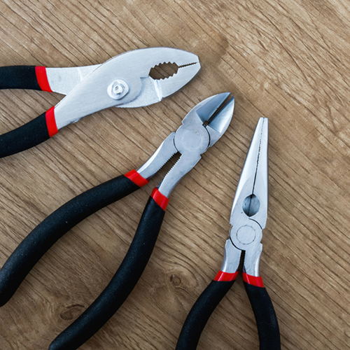 A trio of pliers on a wooden table