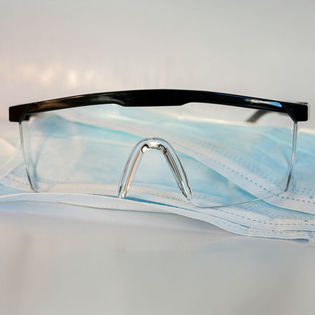 Safety glasses on top of a blue disposable facemask.