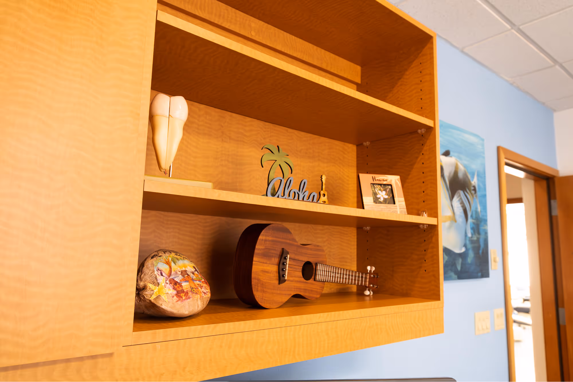 A wooden shelf with a guitar and other items on it.