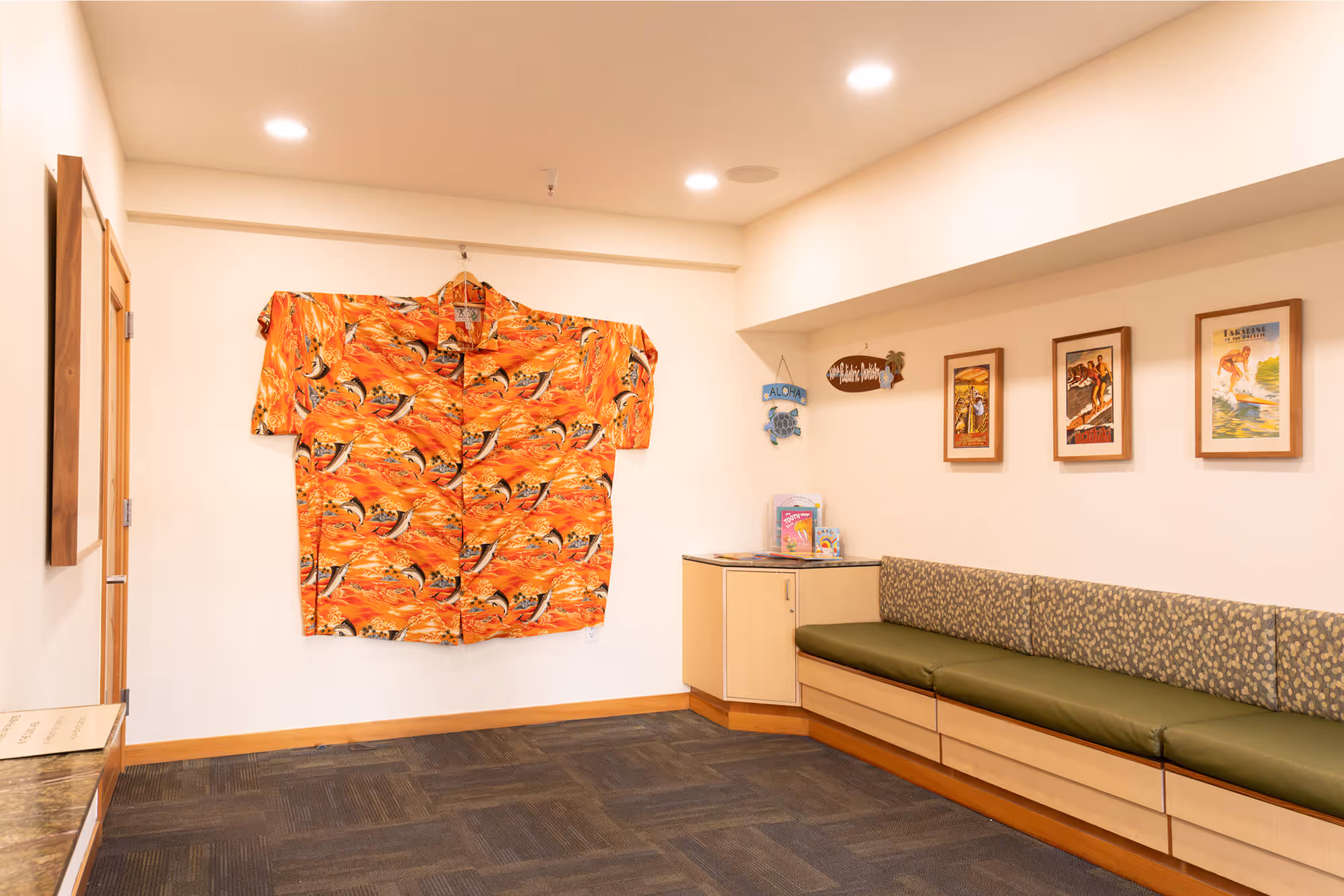 A room with a couch and a shirt hanging on the wall.