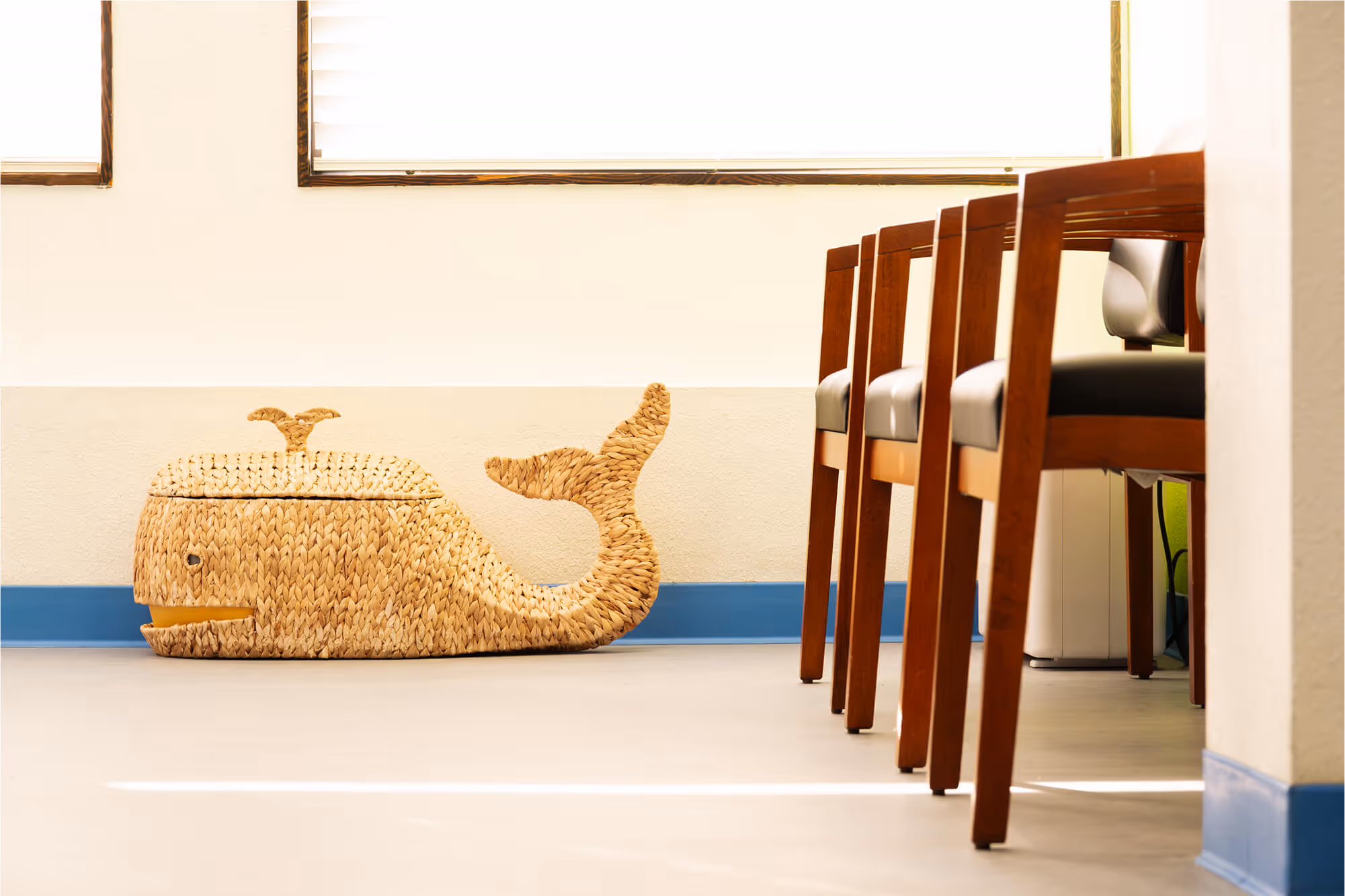 A chair and a basket on the floor in a room.