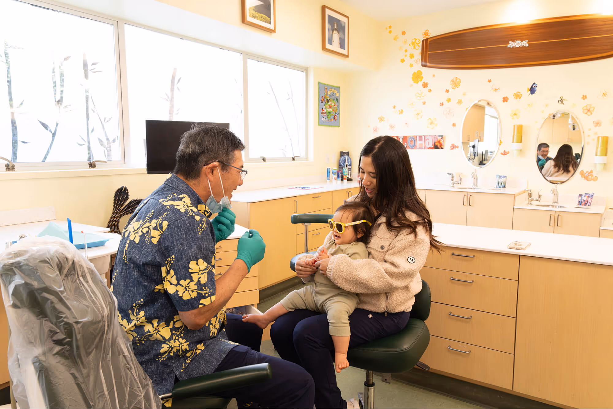 A woman sitting in a dentist chair with a child.