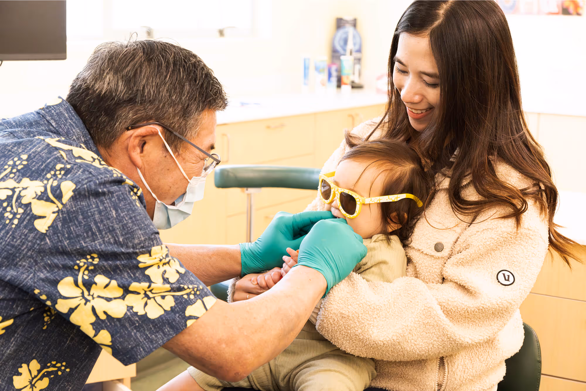 A young girl getting her teeth checked by a dentist.