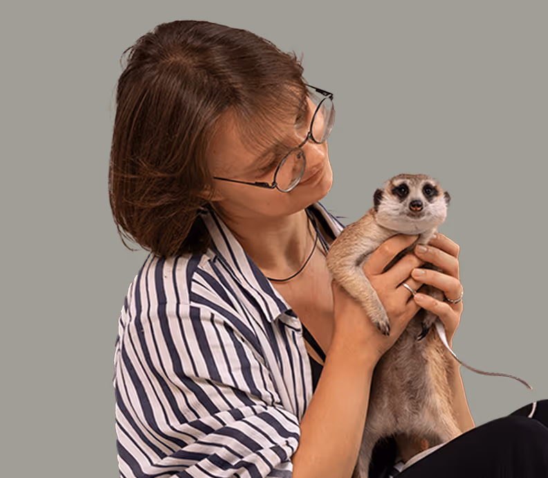 Eine Frau mit einem Erdmännchen in der Hand