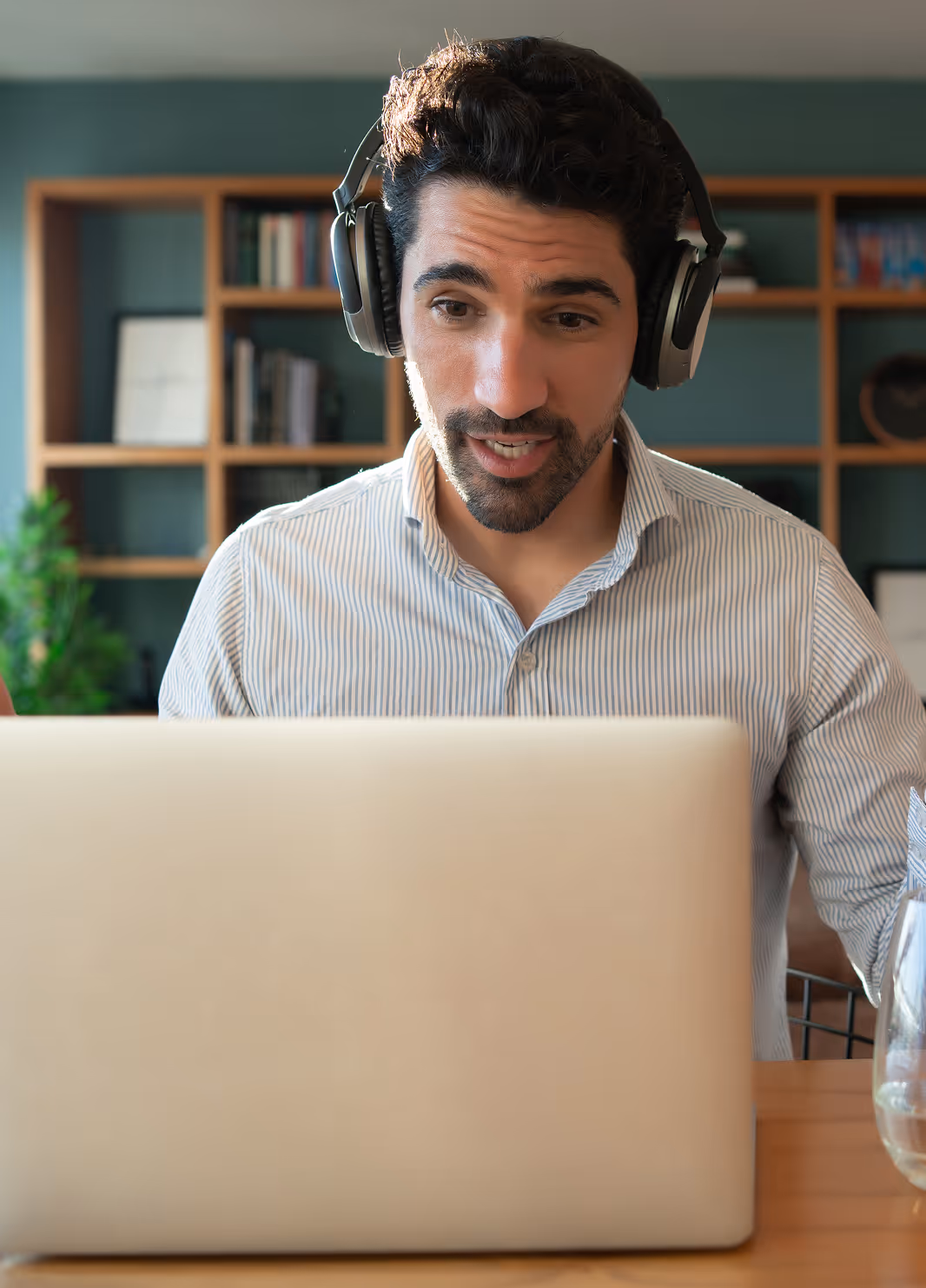 Person wearing headphones in front of a laptop to depict a video
call

