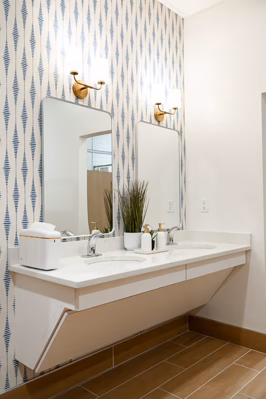 A bathroom sink with quartz countertops and gold finishes.