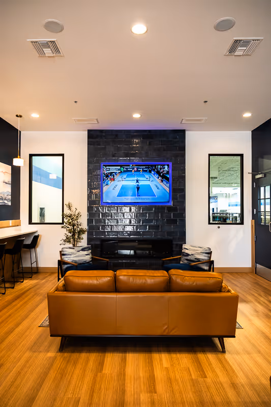 The Drop Shot Lounge at The Paddle Lands featuring comfortable seating, a fireplace, and TV.