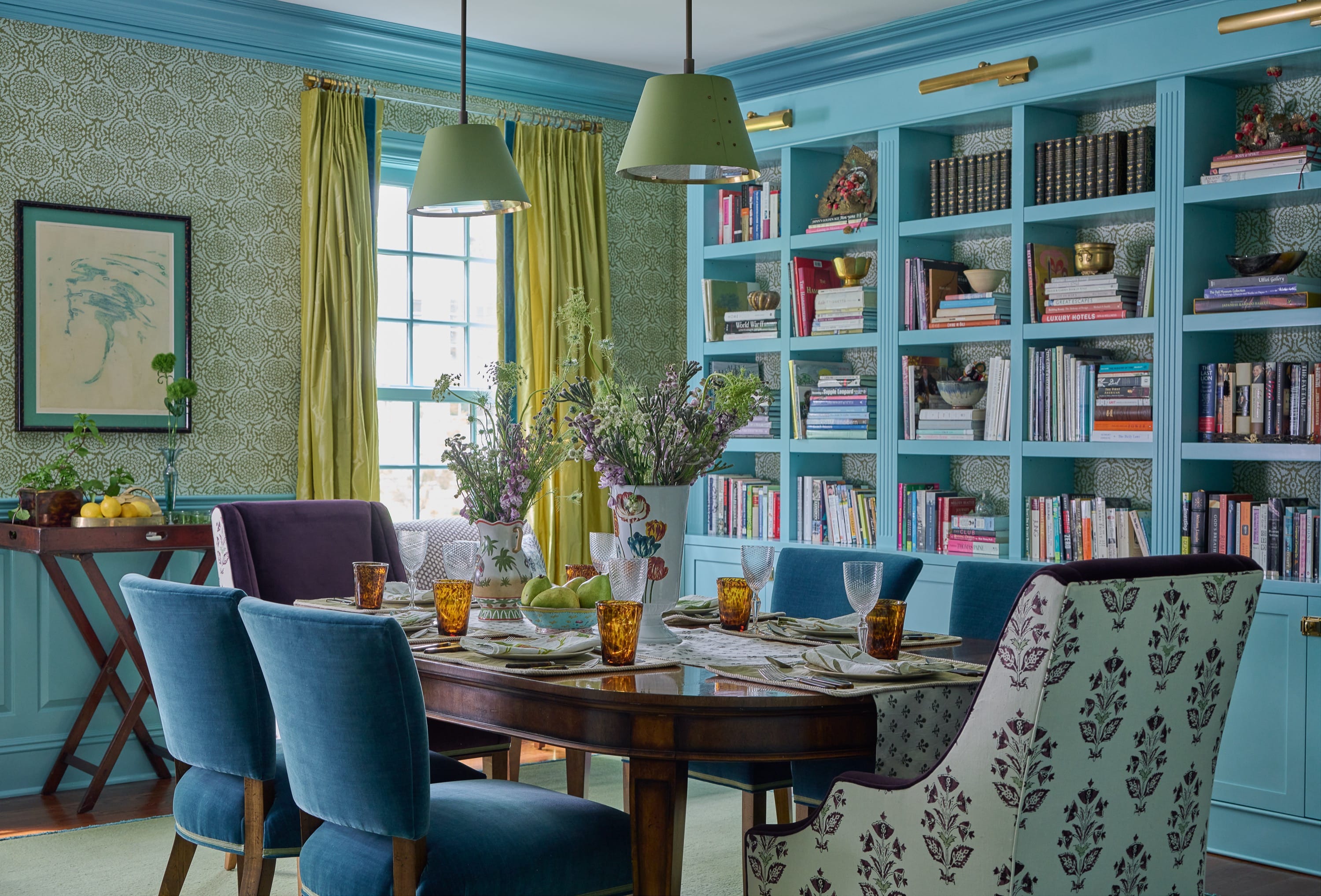 Green and blue dining room with blue shelving designed by Brooke Crew Interiors.