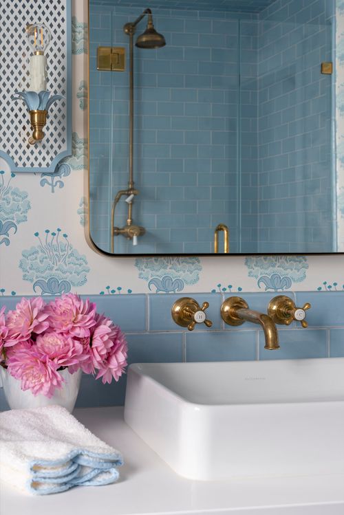 Bathroom sink with gold fixtures and flowers.
