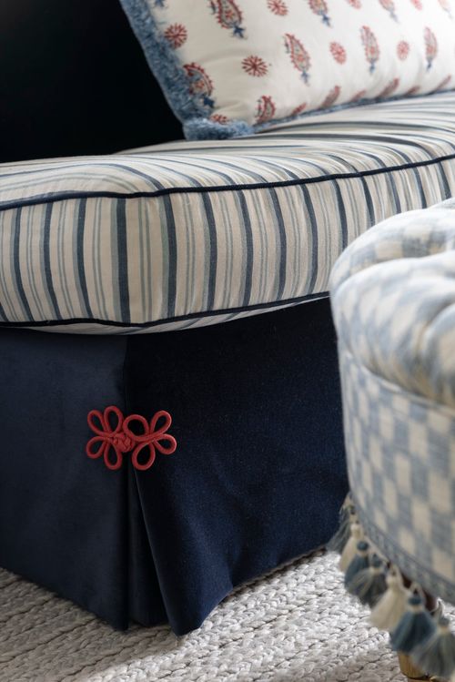 Close-up of striped chair with red detail.