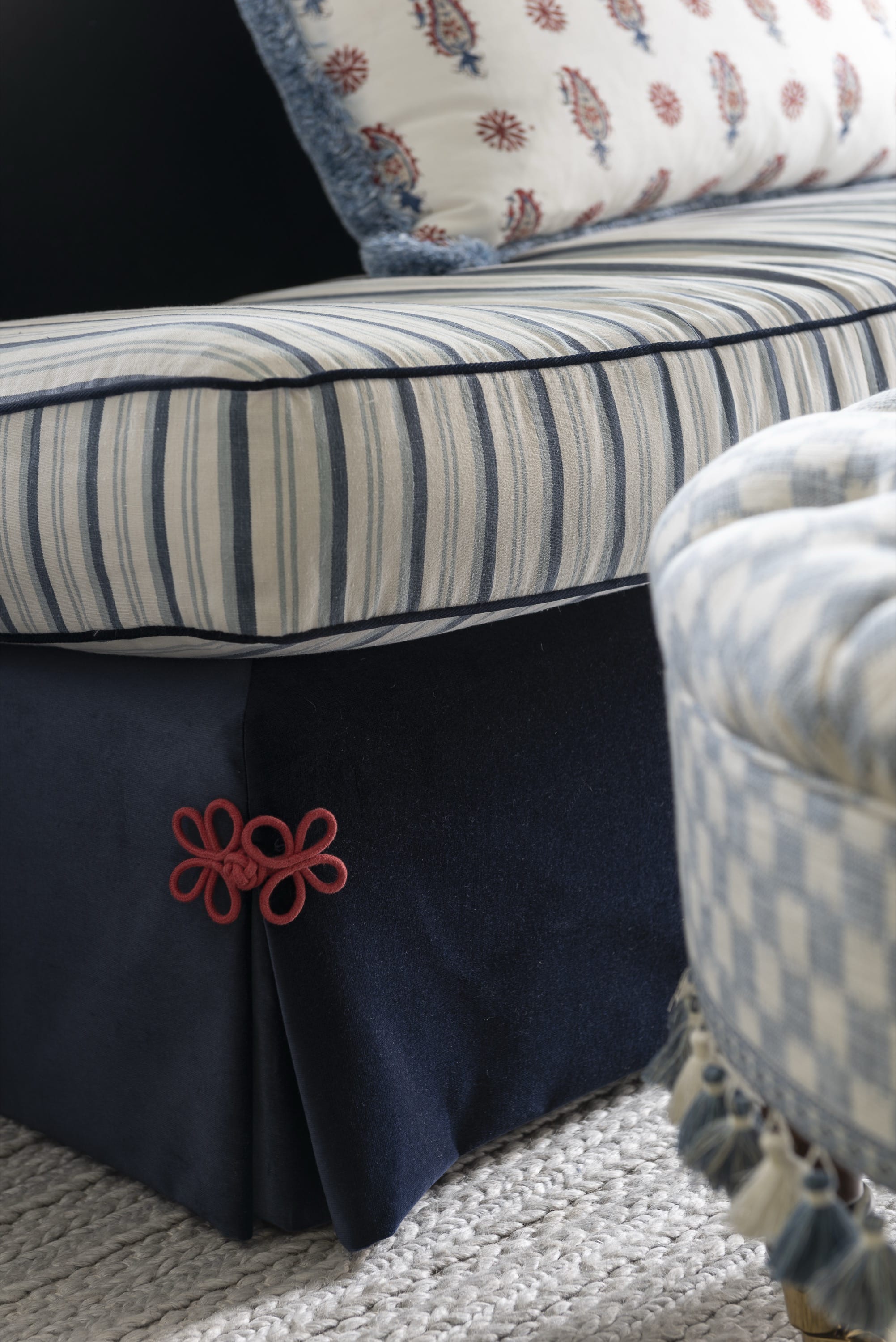 Close-up of striped chair with red detail.