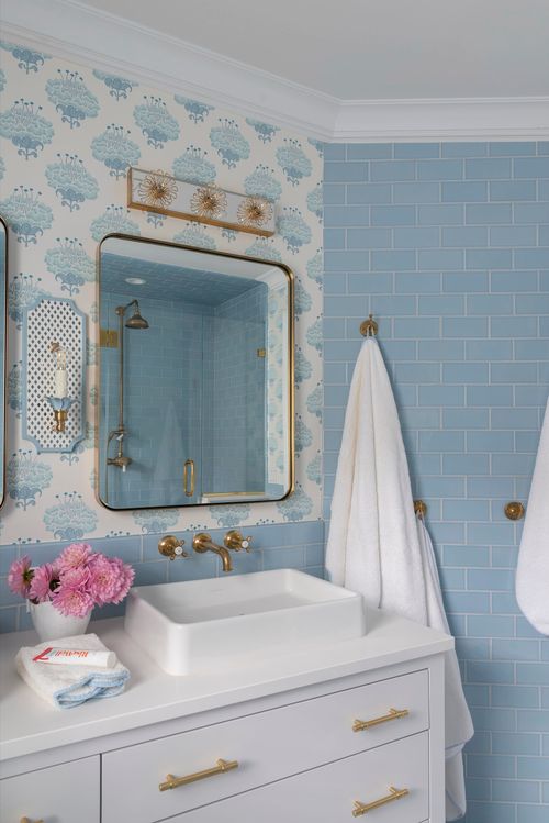 Bathroom vanity with gold mirror and lights.